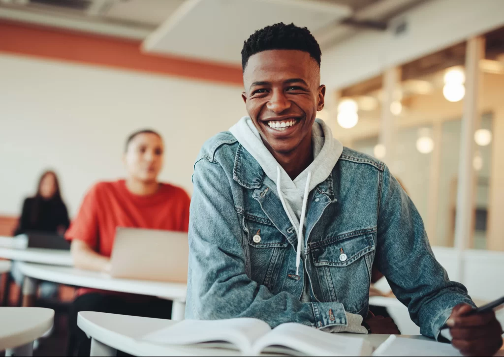 student sitting in classroom smiling